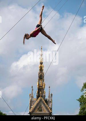 London, UK. 21st August, 2018. Young women keep cool in 27c heat by appearing to fly over the Albert Memorial in Kensington, London. They are they training with the Flying Trapeze School (www.gorillacircus.com) Credit: David Thorpe/Alamy Live News Stock Photo