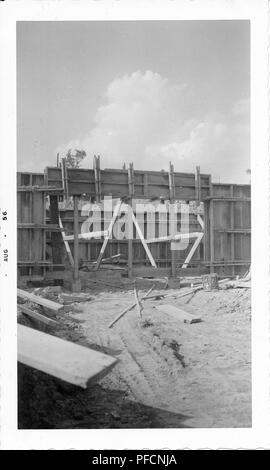 Black and white photograph, showing the framing for a building, with mounds of dirt and lengths of wood visible on the ground, likely photographed in Ohio, August, 1956. () Stock Photo