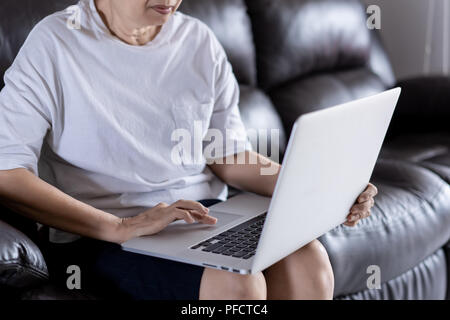 Elderly woman using her computer in home and using laptop Stock Photo