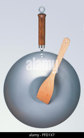 Wok with wooden spoon inside, view from above. Stock Photo