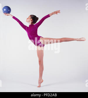 Girl holding blue ball in right hand. Stock Photo