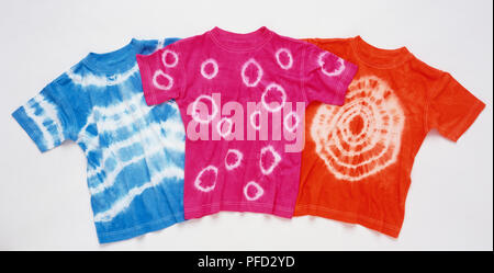 Three dyed t-shirts, red pink and blue respectively and each with different patterns. Stock Photo