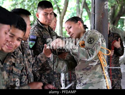 1st. Lt. Katrina F. Simpson, infantry officer, New Hampshire Army National Guard, demonstrates the basics of knot tying to a group of El Salvadoran humanitarian response soldiers in San Juan Opico, El Salvador, June 5. Simpson was a part of a contingent of NHANG soldiers who visited in continuance of NH's relationship with San Salvador in the State Partnership Program. The training featured an exchange of best practices for rescue techniques, command and control operations and ways to enhance reaction times and interoperability between all organizations involved in swift water response mission Stock Photo