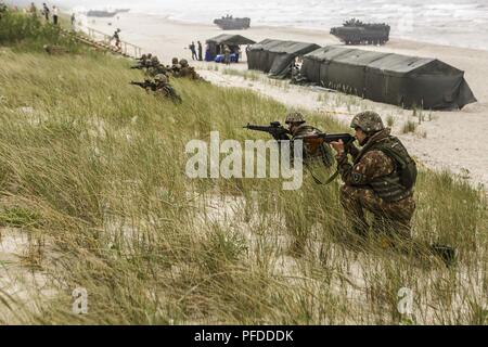 NEMERSITA, Lithuania (June 4, 2018) Romanian Marines assigned to the 307th Naval Infantry Battalion with U.S. Marines assigned to Fox Company, Battalion Landing Team, 2nd Battalion, 6th Marine Regiment, 26th Marine Expeditionary Unit, set security positions during a multilateral amphibious landing during exercise Baltic Operations (BALTOPS) 2018 in Nemersita, Lithuania, June 4. BALTOPS is the premier annual maritime-focused exercise in the Baltic region and one of the largest exercises in Northern Europe enhancing flexibility and interoperability among allied and partner nations. (Marine Corps Stock Photo