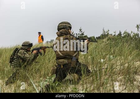 NEMERSITA, Lithuania (June 4, 2018) A Romanian Marine assigned to the 307th Naval Infantry Battalion and a U.S. Marine assigned to 26th Marine Expeditionary Unit, provide security during a multilateral amphibious landing during exercise Baltic Operations (BALTOPS) 2018 in Nemersita, Lithuania, June 4. BALTOPS is the premier annual maritime-focused exercise in the Baltic region and one of the largest exercises in Northern Europe enhancing flexibility and interoperability among allied and partner nations. (Marine Corps Stock Photo