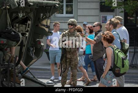 U.S. Army 2nd Lt. Emilie Vanneste, a communications officer and platoon leader assigned Regimental Engineer Squadron, 2d Cavalry Regiment, answers questions from the Lithuanian public about her units Stryker armored vehicle during a static display in Vilnius, Lithuania, June 10, 2018. The static display was part of a ceremony recognizing Pennsylvania and Lithuania’s 25th year participating in the state partnership program. These activities took place during Saber Strike, which is a multinational exercise scheduled to run from June 3-15 that tests NATO’S enhanced forward presence (eFP) battle g Stock Photo