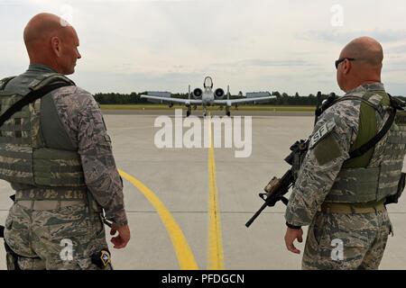 LIELVARDE AIR BASE, Latvia —Senior Master Sgt. Michael Miller, and Master Sgt. Christopher Anderson, both defenders with the 127th Security Forces Squadron, Selfridge Air National Guard Base, Mich., watch an A-10 Thunderbolt II aircraft, also from Selfridge, taxi across the airfield at Lielvarde Air Base, Latvia, during  Saber Strike 18 on June 11, 2018.  Saber Strike is a longstanding U.S. Army Europe-led cooperative training exercise, designed to enhance readiness and interoperability among allies and regional partners. Stock Photo