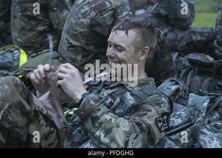 U.S. Army Reserve Sgt. Taylor Nelson, an intelligence analyst with the North East Cyber Protection Center, 335th Signal Command (Theater), relaxes following the ruck march event of the 2018 U.S. Army Reserve Best Warrior Competition at Fort Bragg, North Carolina, June 11, 2018. The grueling, multifaceted competition evaluated U.S. Army Reserve Soldiers in the ruck march, the Excellence in Competition pistol range, the German Armed Forces Proficiency badge and several other events with more challenges to come. Stock Photo