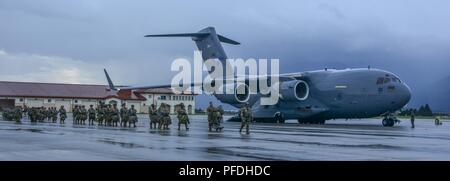 The tail of the US Air Force C-17 Globemaster reaches to the stormy sky as  paratroopers from the 173rd Airborne Brigade board the aircraft to conduct  a parachute assault onto Juliet Drop