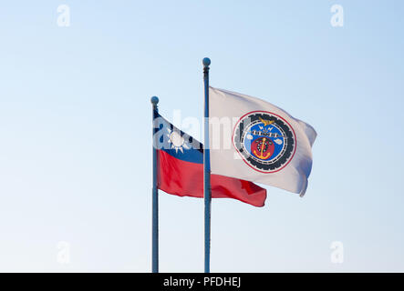 Isolated Taiwan national flag next to Taiwan naval communications flag in front of clear light blue sky Stock Photo