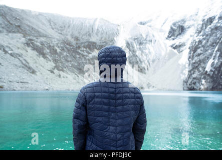 Rear view of man watching the turquoise lagoon in Huascaran National Park. Outdoor lifestyle, wanderlust. Laguna 69, Ancash Region, Peru. Jul 2018 Stock Photo