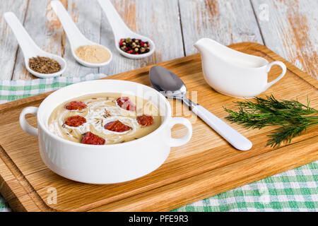 delicious Beer and cream spicy Soup with Kielbasa Sausage sprinkled with caraway in white soup cup on chopping board, spices on background, authentic  Stock Photo