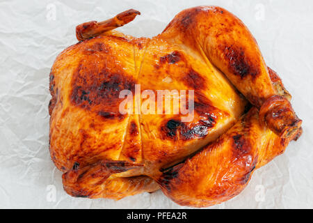 delicious whole chicken roasted in oven on parchment paper, close-up, view from above Stock Photo