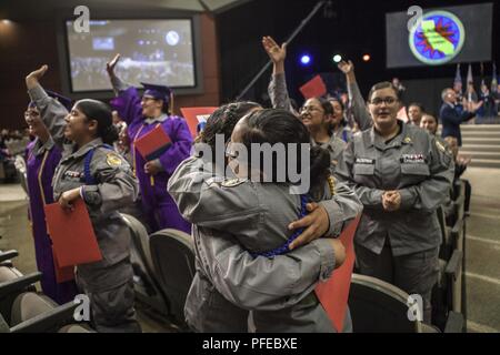 Female cadets cheer and embrace during the Sunburst Youth Challenge Academy Class 21 commencement ceremony, June 9, 2018, in Los Alamitos, California. More than 150 cadets in the academy's 21st class walked the stage to receive certificates of completion for the 5.5 month residential phase of the 17.5 month National Guard Challenge Program. Residential phase graduates now enter into a yearlong mentorship phase to finish the program. Stock Photo
