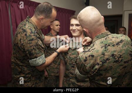 CAMP FOSTER, OKINAWA, Japan – Lance Cpl.  Roy Harris Jr., middle, is pinned by Lt. Gen. Daniel J. O’Donohue, Left, and Brig. Gen. Paul J. Rock Jr. during his meritorious promotion ceremony June 6 aboard Camp Foster, Okinawa, Japan. Harris was meritoriously promoted to lance corporal by O’Donohue. Harris is from Levittown, Pennsylvania where he graduated from Bucks County Technical High School. O’Donohue is the deputy commandant of information with Headquarters Marine Corps. Rock is the commanding general of Marine Corps Installations Pacific and Marine Corps Base Camp Butler. Stock Photo