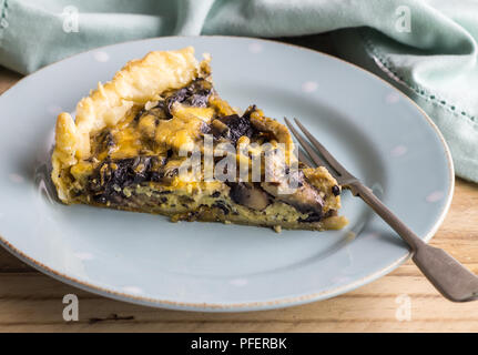 Mushroom tart slice close up on plate with fork - Mushroom pie piece background - Mushroom quiche slice Stock Photo