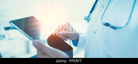 Doctor using tablet in clinic. Digital patient registration system. Wide internet banner concept Stock Photo