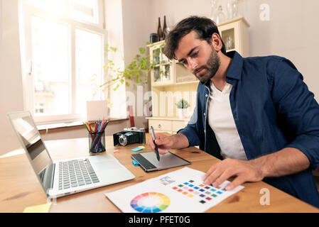 Graphic designer working on digital tablet. Freelancer working at home. Stock Photo