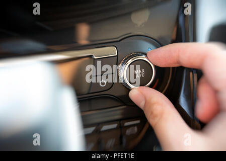 Man turning on car air conditioning system. Air conditioning button inside a car. Stock Photo