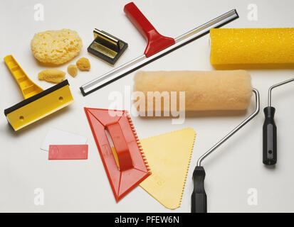 Selection of alternative painting equipment, synthetic painting pad, natural sponges, window cleaner's squeegee, car windscreen scraper, credit card, plastic D.I.Y. spatula, comb-edge D.I.Y. scrapers, lambswool paint roller, texture paint roller. Stock Photo