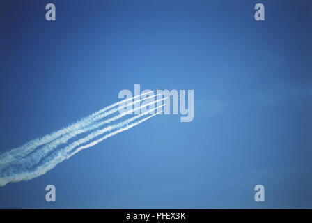 Contrails behind aircraft flying in formation at air show, blurred motion, low angle view Stock Photo