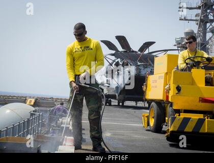 5TH FLEET AREA OF OPERATIONS (June 6, 2018) Aviation Boatswain's Mate (Handling) 3rd Class Devin Hubbard, from Bainbridge, Ga., uses a pressure washer to clean the flight deck aboard the Wasp-class amphibious assault ship USS Iwo Jima (LHD 7), June 6, 2018. Iwo Jima, homeported in Mayport, Fla., is on deployment to the U.S. 5th Fleet area of operations in support of maritime security operations to reassure allies and partners, and preserve the freedom of navigation and the free flow of commerce in the region. Stock Photo