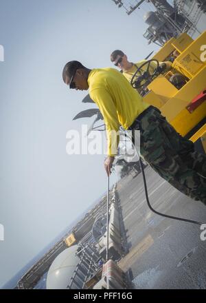 5TH FLEET AREA OF OPERATIONS (June 6, 2018) Aviation Boatswain's Mate (Handling) 3rd Class Devin Hubbard, from Bainbridge, Ga., uses a pressure washer to clean the flight deck aboard the Wasp-class amphibious assault ship USS Iwo Jima (LHD 7), June 6, 2018. Iwo Jima, homeported in Mayport, Fla., is on deployment to the U.S. 5th Fleet area of operations in support of maritime security operations to reassure allies and partners, and preserve the freedom of navigation and the free flow of commerce in the region. Stock Photo