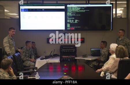 Airmen from the 836th Cyberspace Operations Squadron discuss defensive cyberspace operations during a civic leader tour at Joint Base San Antonio-Lackland, Texas, May 31, 2018. The civic leaders visited the base with Gen. Mike Holmes, commander Air Combat Command, to introduce them to 24th Air Force’s cyberspace mission and 25th AF’s intelligence, surveillance and reconnaissance mission. Stock Photo