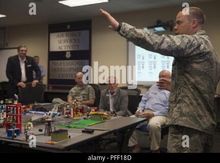 Capt. Justin Ball, 390th Cyberspace Operations Squadron Weapons and Tactics chief, explains the purpose of the 90th Cyber Operations Squadron “Bricks-in-the-Loop” model to Gen. Mike Holmes, commander Air Combat Command, and civic leaders during a tour at Joint Base San Antonio-Lackland, Texas, May 31, 2018. The model is used as a cyber training tool to teach cyber Airmen information technology and operational technology network defense. The tour was hosted to introduce attendees to 24th Air Force's cyberspace mission and 25th AF's intelligence, surveillance and reconnaissance mission. Stock Photo