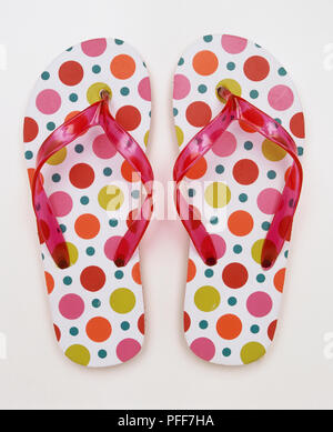 A pair of flip-flops with pink plastic bands and dotted soles. Stock Photo