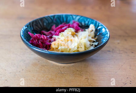 Dish of home made sauerkraut with shallow depth of field - two types of fermented food from red and green cabbage and carrot Stock Photo