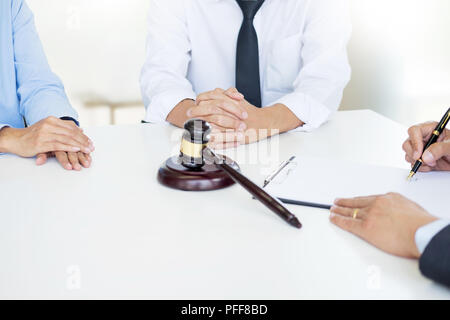 Angry couple arguing telling their problems to Judge gavel deciding on marriage to conclude an agreement on the divorce. They quarrel and argue with e Stock Photo