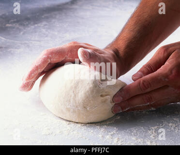Repeat the kneading action, gently folding, pushing, and rotating with your hands. Stock Photo
