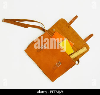 Tan leather satchel with ruler and school books inside, view from above. Stock Photo