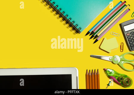 various school and office stationary and gadgets lying on a yellow background. free space for text Stock Photo