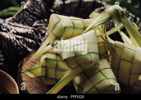 Ketupat, the traditional diamond-shaped rice cake in casing of woven coconut leaf; highly popular during Eid celebrations. Stock Photo