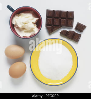 Two eggs, broken chocolate bar, bowls of sugar and fat, view from above Stock Photo