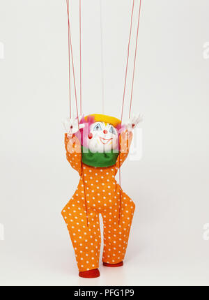 Clown puppet hanging from strings, hands up in air, front view Stock Photo  - Alamy