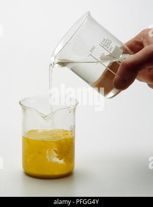 Solutions of potassium and iodide in water and solution of lead nitrate in water being mixed together, turning yellow and forming a lead iodide Stock Photo