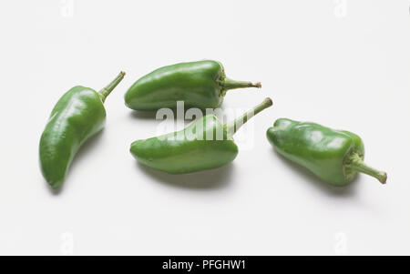 Four green chillies on white background Stock Photo - Alamy