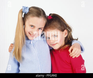 Two girls with their arms around each other Stock Photo - Alamy