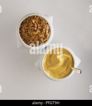 Pots of coarse-grained and smooth Dijon mustard, view from above. Stock Photo
