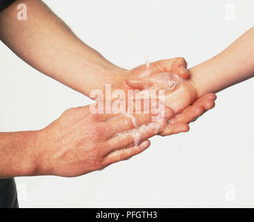 Adult washing a child's hand, close up. Stock Photo