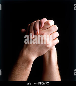 Man clasping hands together, close-up Stock Photo