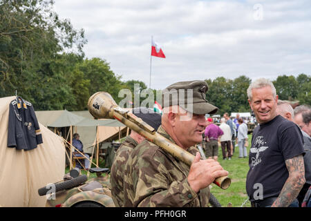 Adult male seen dressed in WW2 Germany army uniform caring a rocket propelled anti-tank grenade. Seen at a WW2 enactment scene in the UK Stock Photo