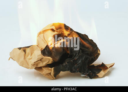 Crumpled brown paper burning, side view Stock Photo