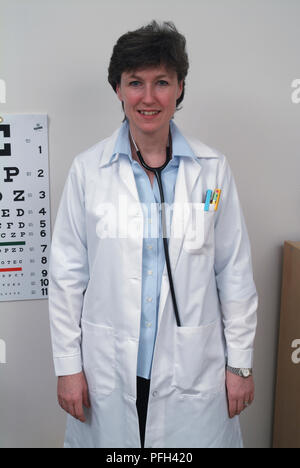 In a laboratory, a woman wearing a white medical tunic holds a tray ...