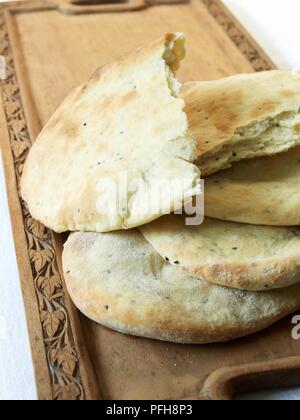 Naan breads on wooden serving tray, close-up Stock Photo