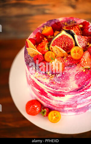 Beautiful bright cake on a porcelain cake stand decorated with fruits. Close up. Top view Stock Photo