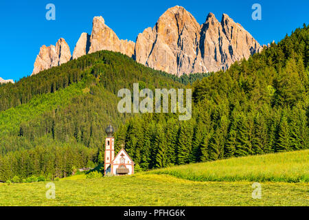View of the small Baroque Church of St. Johannes of Nepomuk in Ranui in sunny day with the forest of pine trees and the famous Mount Geissler Spitzen  Stock Photo